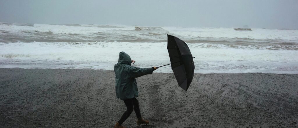 Woman on the beach with umbrella in her hand