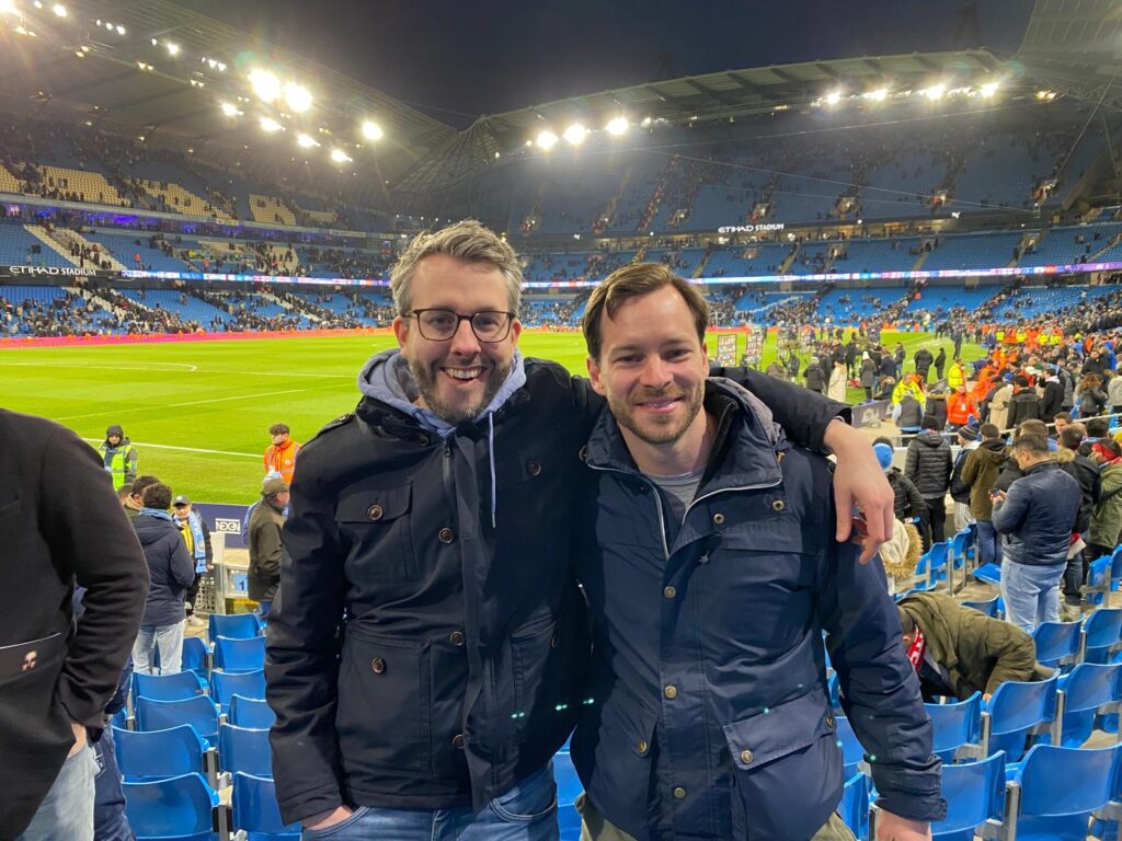 Two people standing in a soccer stadium during a European league