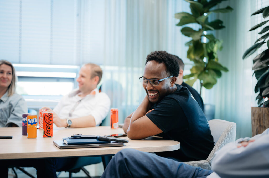 Three people sitting at a table and having a laugh during a quarterly meeting